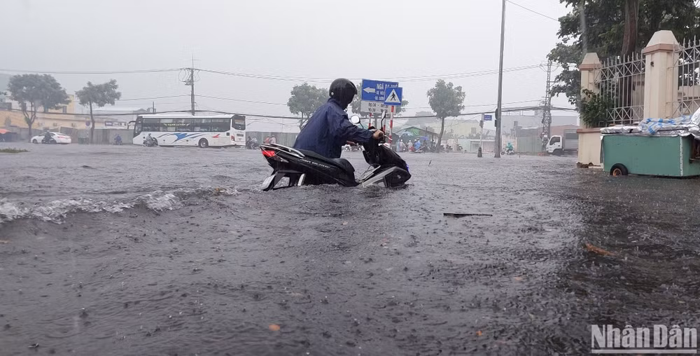 Người dân dắt xe máy qua khu vực ngập sâu.