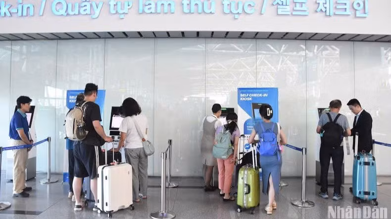 Hành khách làm thủ tục tại quầy tự gửi hành lý (self-bag drop) tại Nhà ga T2. (Ảnh: ANH ĐÀO)