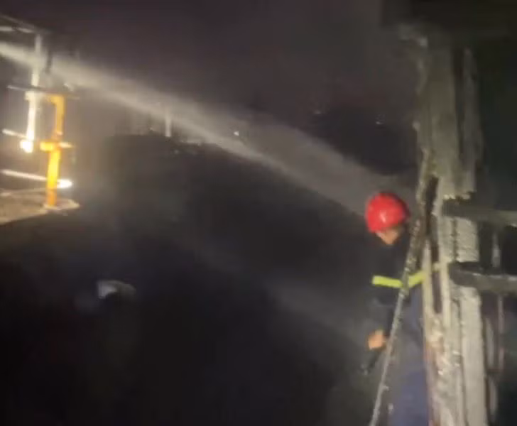 Các chiến sĩ nỗ lực khống chế ngọn lửa không để cháy lan rộng ra các tàu cá đang neo đậu chung quanh. Ảnh Công an cung cấp