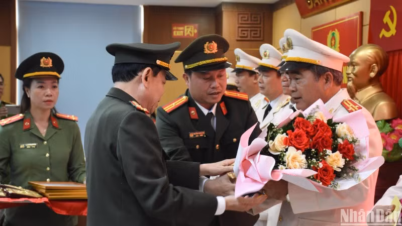 Đại tá Trần Đình Liên, Phó Bí thư, Phó Giám đốc Công an thành phố Đà Nẵng trao quyết định nghỉ hưu và tặng hoa cảm ơn các đồng chí cấp phó trưởng phòng nghỉ hưu trước tuổi. (Ảnh: ANH ĐÀO)