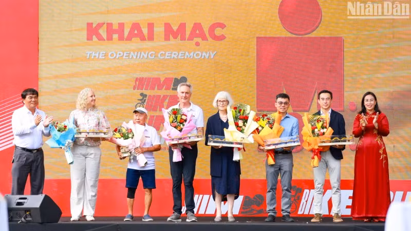 Bà Nguyễn Thị Anh Thi, Phó Chủ tịch Ủy ban nhân dân thành phố Đà Nẵng và ông Nguyễn Trọng Thao, Phó Giám đốc Sở Văn hóa, Thể thao và Du lịch thành phố Đà Nẵng tặng hoa, quà lưu niệm cho các đơn vị đồng hành và hai huyền thoại, Mark Allen - nhà vô địch 6 lần tại Giải Vô địch thế giới Ironman, và Yee Sze Mun - vận động viên 88 tuổi đến từ Malaysia. (Ảnh: ANH ĐÀO)