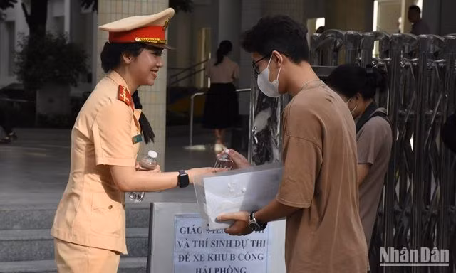 Chiến sĩ cảnh sát giao thông trao quà, động viên thí sinh thi tốt. (Ảnh: ANH ĐÀO)