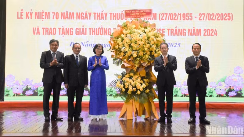 Đồng chí Nguyễn Văn Quảng, Ủy viên Ban Chấp hành Trung ương Đảng, Bí thư Thành ủy, Trưởng đoàn Đại biểu Quốc hội đơn vị thành phố Đà Nẵng và Phó Bí thư Thường trực Thành ủy Nguyễn Đình Vĩnh trao tặng lẵng hoa chúc mừng Ngành y tế Đà Nẵng nhân ngày 27/2. (Ảnh: ANH ĐÀO)