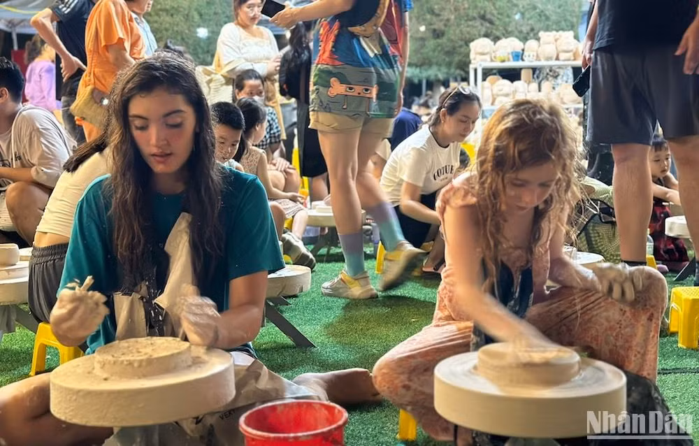 Du khách nước ngoài trải nghiệm làm gốm. (Ảnh: ANH ĐÀO)