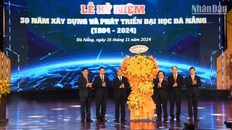 Bộ trưởng Giáo dục và Đào tạo Nguyễn Kim Sơn tặng hoa chúc mừng Đại học Đà Nẵng 30 năm xây dựng, phát triển. (Ảnh: ANH ĐÀO)