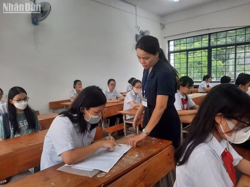 Cán bộ coi thi hướng dẫn thí sinh hoàn thành các thủ tục, giấy tờ thi. (Ảnh: ANH NGỌC)