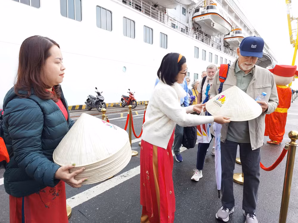 Đại diện Sở Du lịch Đà Nẵng trao tặng nón lá Việt Nam cho các du khách tàu biển sáng nay, Mùng 1 Tết Nguyên đán Ất Tỵ 2025. (Ảnh: ANH ĐÀO)