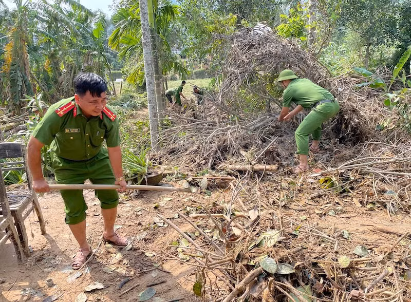 Thượng úy Bùi Văn Hoàng cùng cán bộ chiến sỹ Công an xã Hoà Bắc giúp dân dọn nhà sau bão lũ. Ảnh Công an xã Hoà Bắc