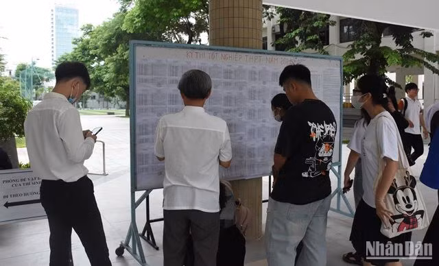 Nhiều phụ huynh đến điểm thi, cùng con xem lại số báo danh và phòng thi. (Ảnh: ANH ĐÀO)