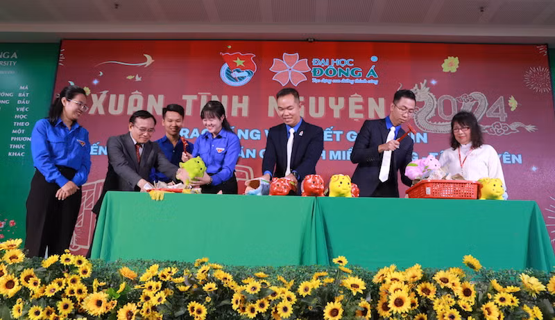 Ban giám hiệu nhà trường và Đoàn trường cùng đập heo đất gây quỹ vé xe Tết tặng sinh viên khó khăn miền trung-Tây Nguyên. (Ảnh: ANH ĐÀO)