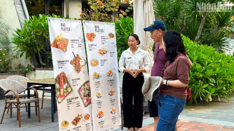 Khách du lịch tìm hiểu, chọn lựa các món ăn đặc sản tại một nhà hàng trên tuyến đường Võ Nguyên Giáp, quận Sơn Trà, thành phố Đà Nẵng. (Ảnh: ANH ĐÀO)