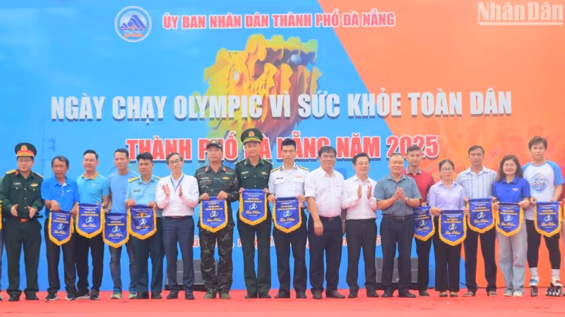 Ban tổ chức trao cờ lưu niệm cho các đơn vị tham gia Ngày chạy Olympic vì sức khỏe toàn dân năm 2025. (Ảnh: ANH ĐÀO)
