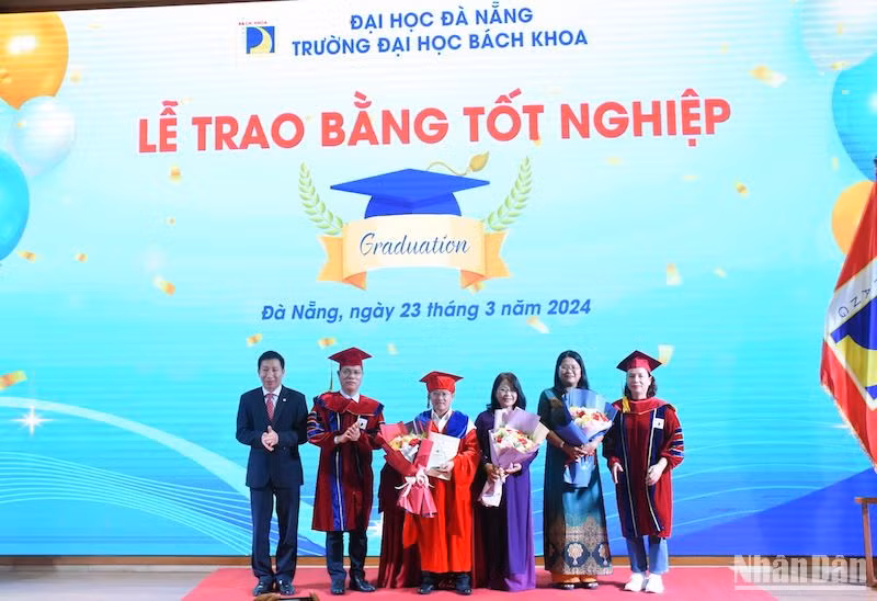 PGS, TS Lê Thành Bắc, Phó Giám đốc Đại học Đà Nẵng và lãnh đạo trường Đại học Bách Khoa trao bằng cho tân Tiến sĩ Đặng Thanh Long, Ngành Công nghệ sinh học, Khoa Hóa. (Ảnh: ANH ĐÀO)
