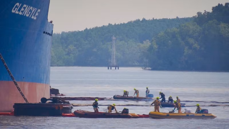 Lực lượng cứu hộ môi trường thu gom dầu và rác thải sau khi tách tàu.