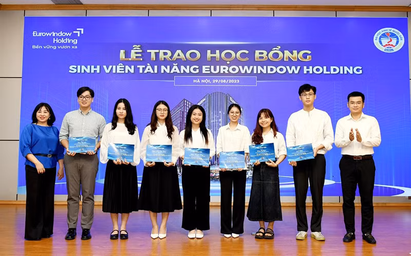 Đại diện Trường đại học Kinh tế quốc dân trao học bổng sinh viên xuất sắc. (Ảnh PHƯƠNG LINH)