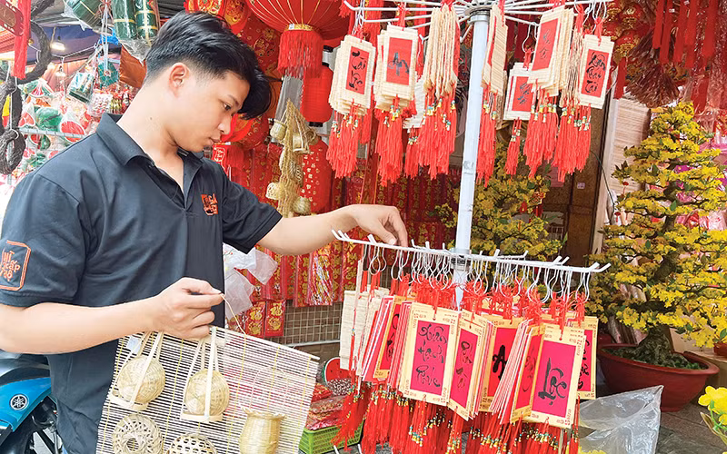Khách hàng lựa chọn đồ trang trí Tết thuần Việt bày bán trên đường Hải Thượng Lãn Ông, Quận 5.