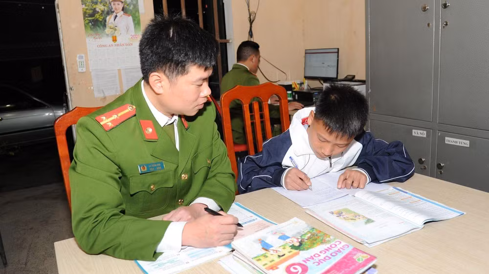 Thượng úy La Tuấn Anh, Công an xã Niêm Sơn, huyện Mèo Vạc tranh thủ dạy cháu Ly Mí Hồng học bài.