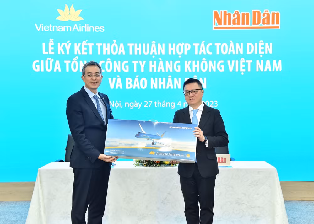 Bí thư Đảng ủy, Chủ tịch Hội đồng quản trị Vietnam Airlines Đặng Ngọc Hòa trao quà lưu niệm tặng Tổng Biên tập Báo Nhân Dân Lê Quốc Minh tại lễ ký kết hợp tác.