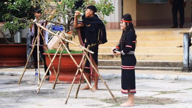 Các em học sinh dân tộc thiểu số tái diễn lễ cúng nước giọt.