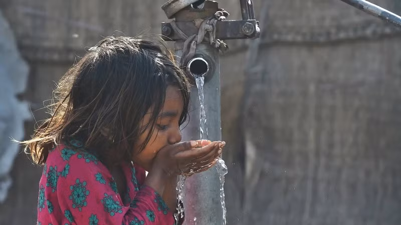 Em nhỏ uống nước từ vòi nước công cộng ở Lahore, Pakistan. (Ảnh: AFP/TTXVN)