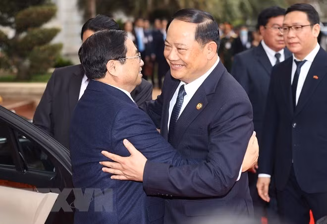 Thủ tướng Lào Sonexay Siphandone đón Thủ tướng Phạm Minh Chính. (Ảnh: Dương Giang/TTXVN)