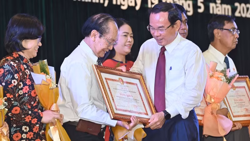 Đồng chí Nguyễn Văn Nên, Ủy viên Bộ Chính trị, Bí thư Thành ủy Thành phố Hồ Chí Minh trao Bằng khen cho bác sĩ Trần Đông A. (Ảnh: Quốc Thanh).