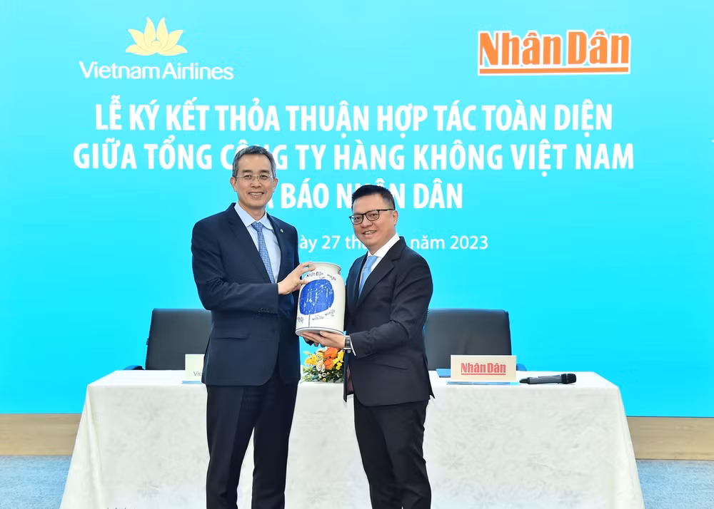 Tổng Biên tập Báo Nhân Dân Lê Quốc Minh trao quà lưu niệm tặng Bí thư Đảng ủy, Chủ tịch Hội đồng quản trị Vietnam Airlines Đặng Ngọc Hòa.