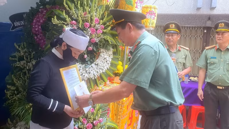 Đại diện Công an tỉnh Cà Mau trao quyết định thăng cấp bậc hàm cho người nhà đồng chí Nguyễn Chí Nguyện tại lễ tang.