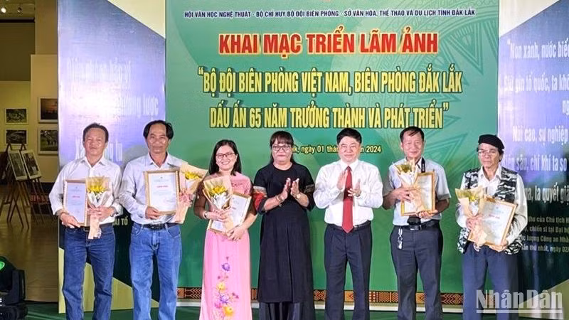 Phó Bí thư Thường trực Tỉnh ủy Đắk Lắk Phạm Minh Tấn và Chủ tịch Hội Văn học nghệ thuật tỉnh Đắk Lắk nhà văn Niê Thanh Mai trao giấy chứng nhận cho các tác giả có ảnh được trưng bày tại triển lãm.