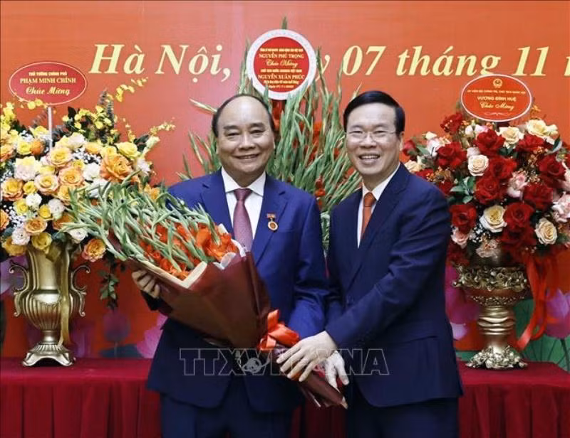 Đồng chí Võ Văn Thưởng, Ủy viên Bộ Chính trị, Thường trực Ban Bí thư trao tặng hoa cho đồng chí Nguyễn Xuân Phúc, Ủy viên Bộ Chính trị, Chủ tịch nước Cộng hòa xã hội chủ nghĩa Việt Nam. (Ảnh: Thống Nhất/TTXVN)
