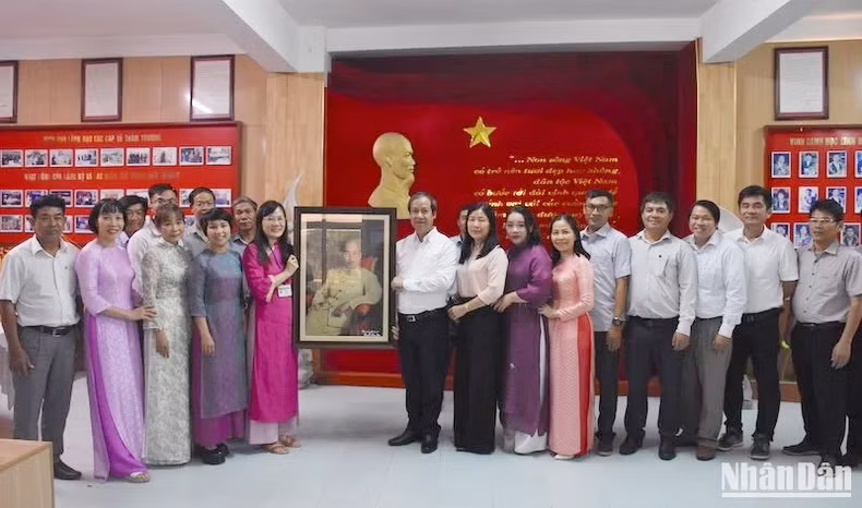 Bộ trưởng Nguyễn Kim Sơn trao tặng bức ảnh Chủ tịch Hồ Chí Minh cho Trường chuyên Lê Quý Đôn, thành phố Đà Nẵng. (Ảnh: ANH ĐÀO)