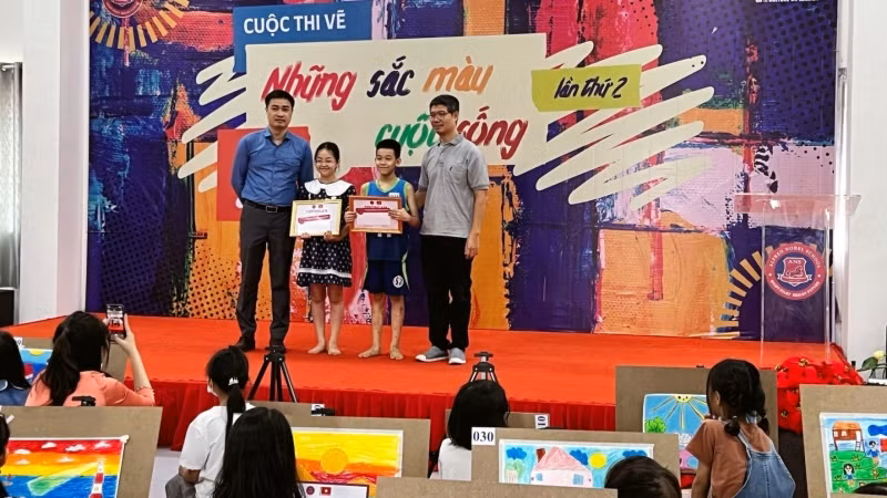 Đại diện Ban tổ chức trao hai giải Nhất cho em Đoàn Nhã Uyên (bên trái) và Ninh Văn Vũ (bên phải).