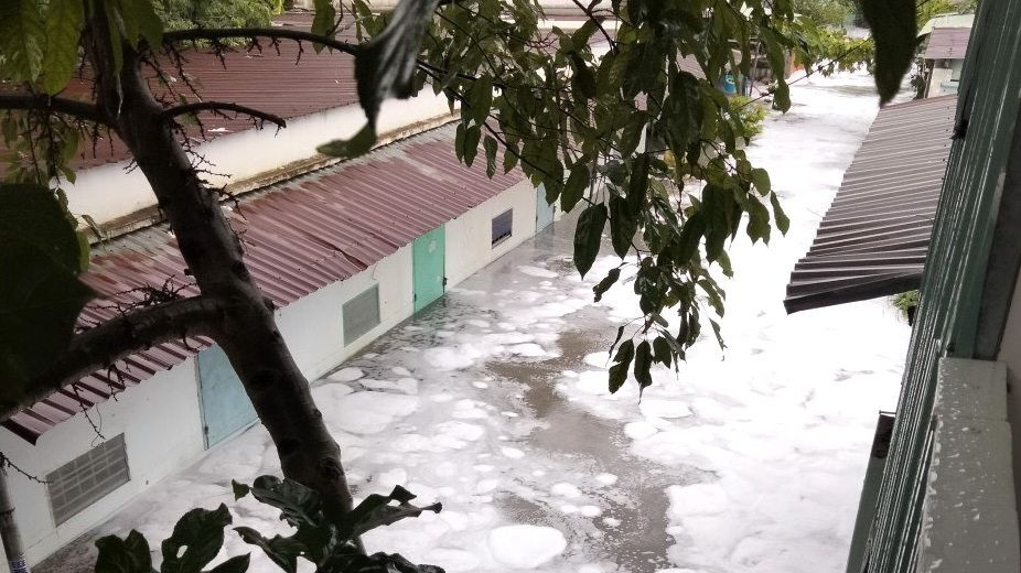 Nước với bọt trắng tràn vào khu dân cư sau mưa lớn ven suối Xiệp, phường Hóa An, thành phố Biên Hòa.