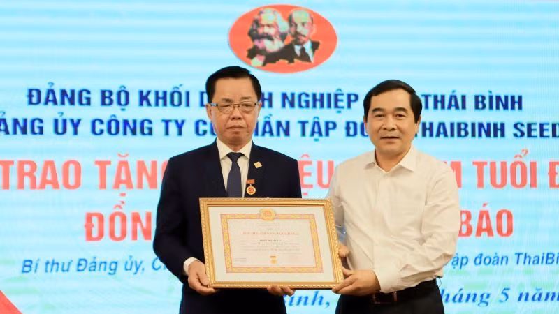 Phó Bí thư Thường trực Tỉnh ủy Thái Bình Nguyễn Tiến Thành (bên phải) trao Huy hiệu 50 năm tuổi Đảng cho đồng chí Trần Mạnh Báo.