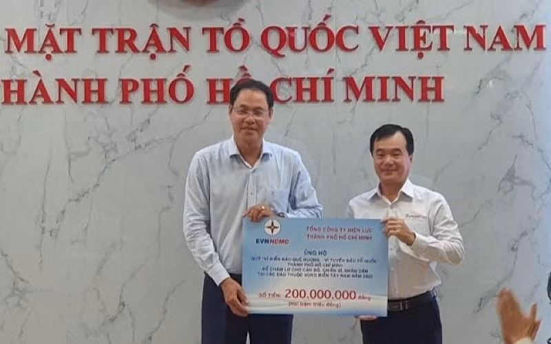 Ông Trần Vũ Quang, Trưởng Ban Kiểm tra - Thanh tra EVNHCMC (bên phải) trao số tiền 200 triệu đồng cho Quỹ “Vì biển đảo quê hương-Vì tuyến đầu Tổ quốc”.
