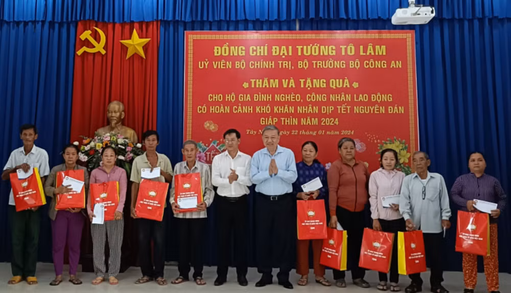 Bộ trưởng Tô Lâm tặng quà và chúc tết các hộ gia đình nghèo. (Ảnh: Báo Công an nhân dân)