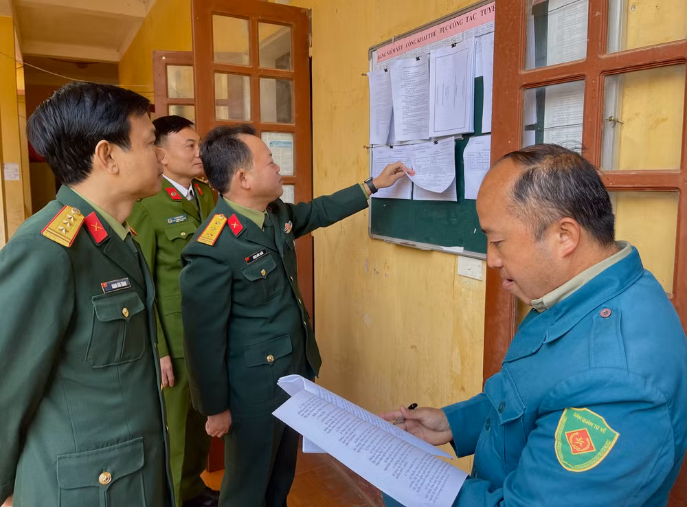 Kiểm tra việc niêm yết danh sách công dân nhập ngũ tại xã vùng cao Lao Chải, huyện Mù Cang Chải.