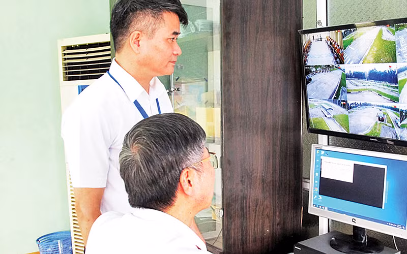 Lực lượng chức năng giám sát các thí sinh dự thi sát hạch cấp giấy phép lái xe ô-tô. (Ảnh HẰNG NGA)