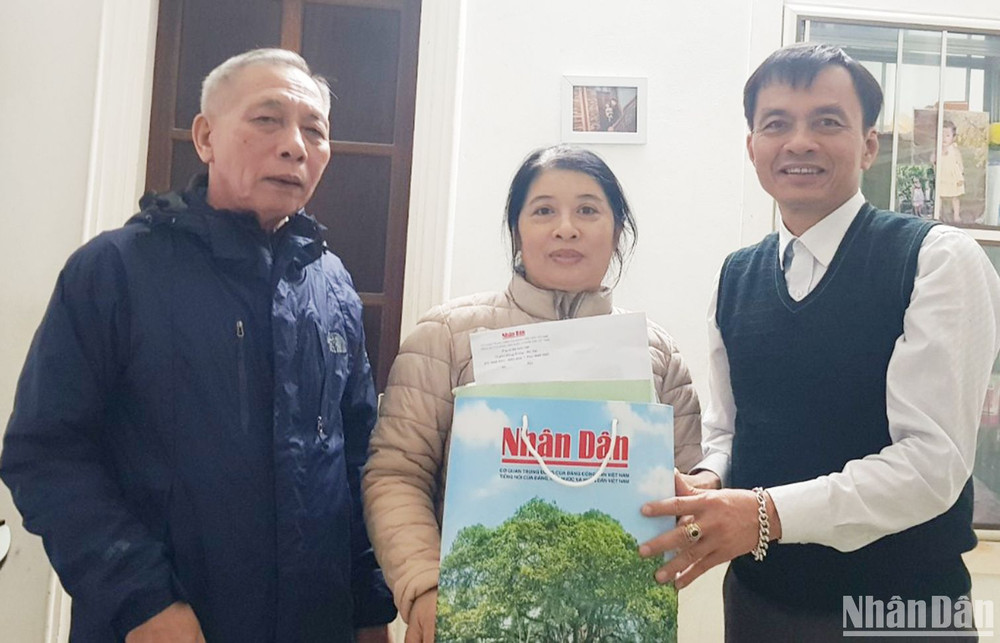 Bí thư Chi bộ Khu phố 5, phường 5, thành phố Đông Hà (bên trái) tặng các ấn phẩm Báo Nhân Dân cho bạn đọc nhân dịp Tết Quý Mão 2023.