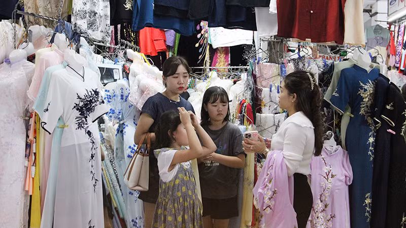 Khách du lịch tìm hiểu về may áo dài lấy liền.