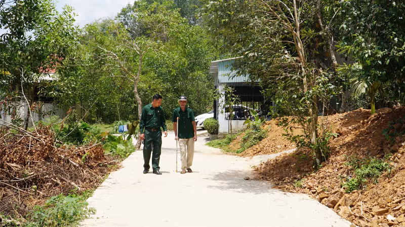 Hai cha con ông Bùi Văn Tượng đi trên con đường mới từ một phần đất gia đình đóng góp.