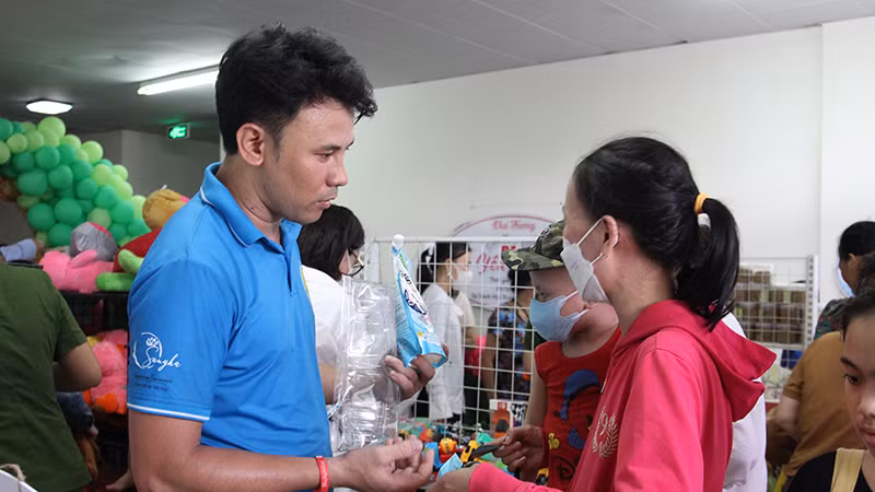 Anh Hồ Ngọc Thanh (bìa trái) đưa "siêu thị 0 đồng" vào bệnh viện.