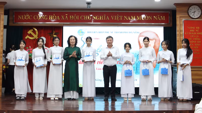 Tặng quà nữ sinh mồ côi vượt khó có thành tích học tập tốt.