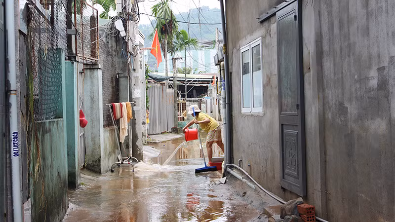 Dọn bùn đất trước lối đi.