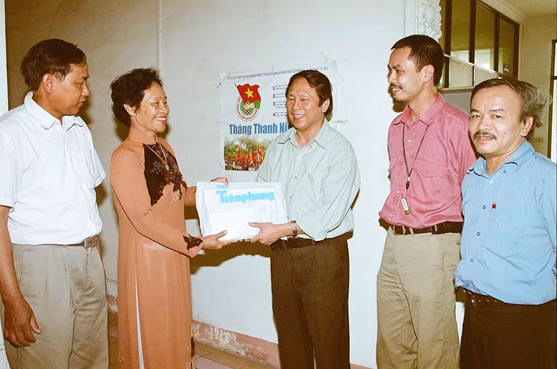 Nhà báo Dương Xuân Nam (giữa) trao quà cho nữ dân quân Ngô Thị Thương, người đã dùng súng trường K44 bắn rơi máy F105 của Mỹ tại Ngã ba Đồng Lộc.