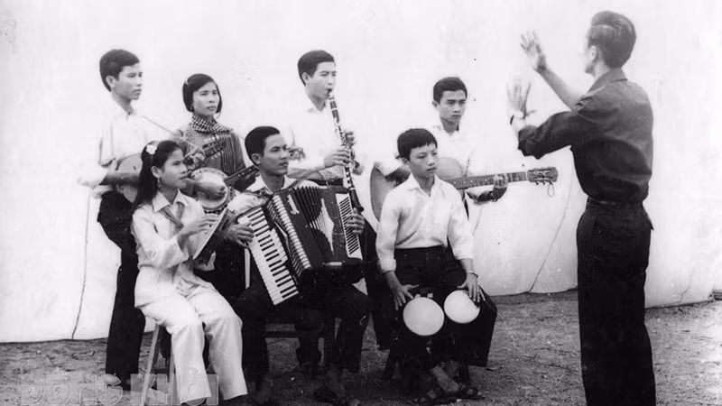 Nhạc sĩ Lan Phong (đứng) chỉ huy anh chị em Đoàn Văn công giải phóng hòa tấu bài nhạc “Giải phóng miền Nam”. Ảnh: Tư liệu 