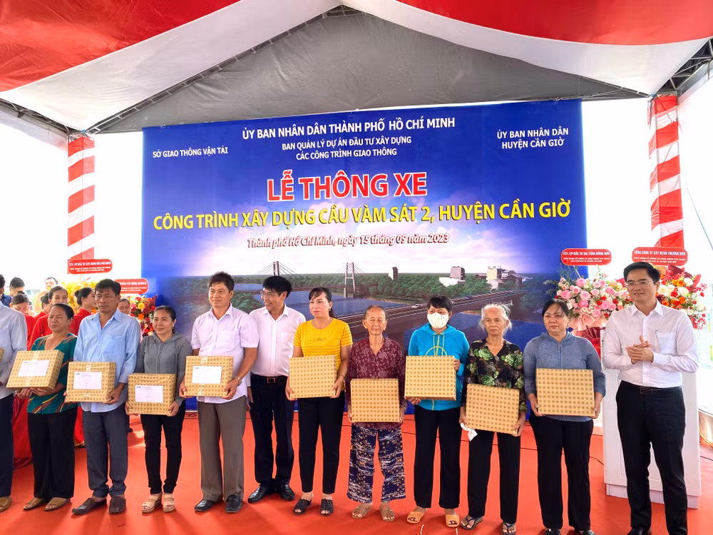 Lãnh đạo địa phương tặng quà cảm ơn bà con nhân dân tích cực giao mặt bằng để công trình cầu Vàm Sát 2 sớm được thi công hoàn tất.