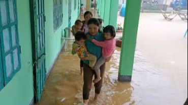 Các cô giáo điểm trường mần non bản Pắc Pạ đưa học sinh ra khỏi điểm trường do bị ngập.