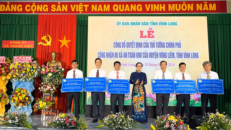 Phó Chủ tịch Ủy ban nhân dân tỉnh Vĩnh Long Nguyễn Thị Quyên Thanh trao bảng hỗ trợ thẻ bảo hiểm y tế cho người dân xã an toàn khu.