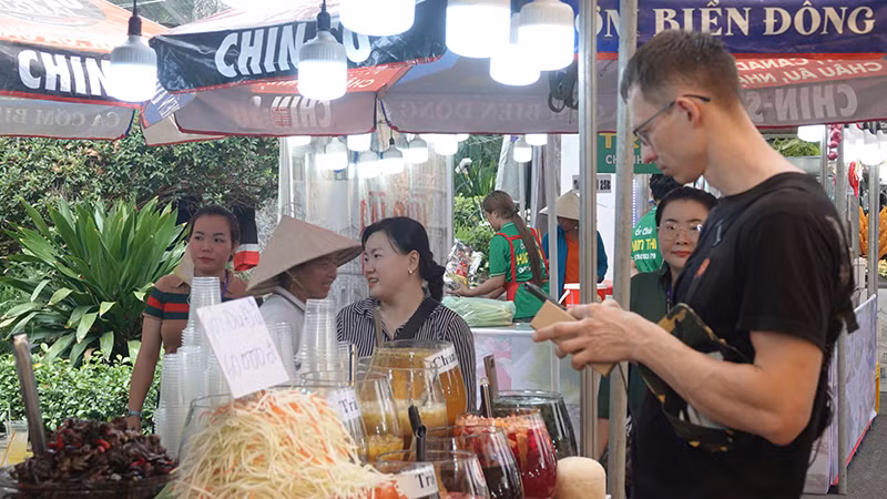 Du khách nước ngoài tìm hiểu ẩm thực Việt tại lễ hội.